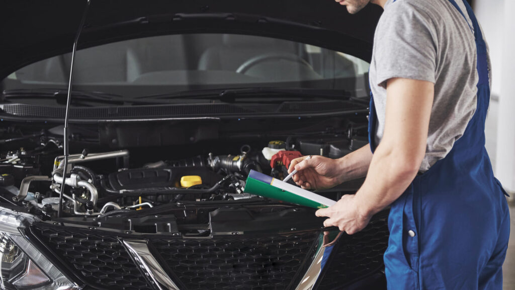 homem realizando inspeção em um carro preto