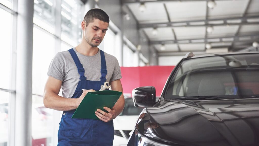 homem inspecionando carro preto