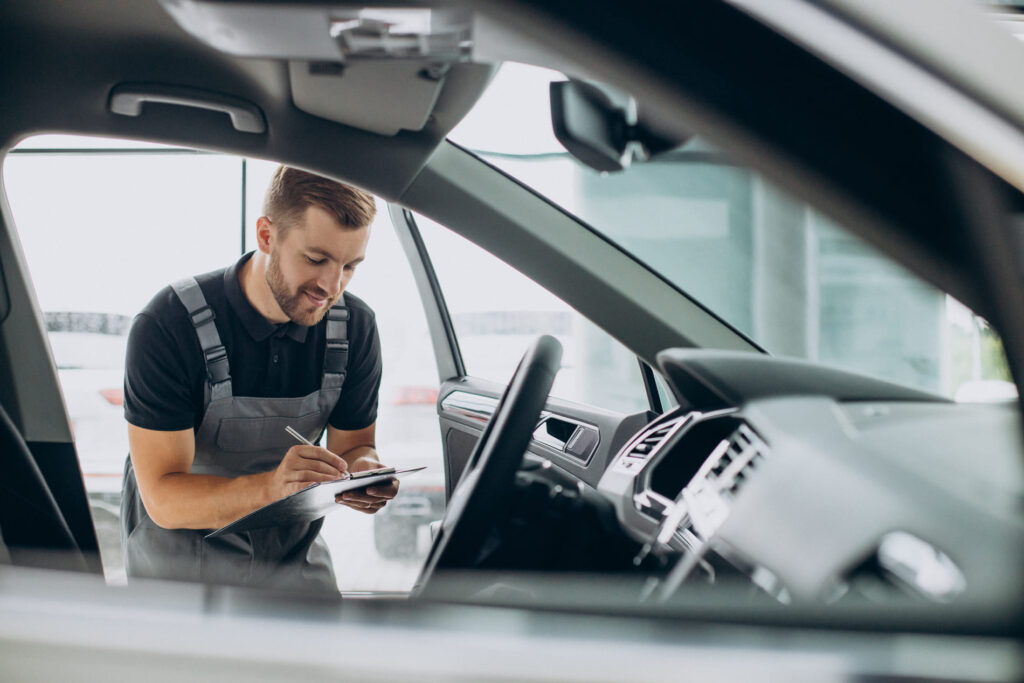 homem realizando inspeção no interior de um carro